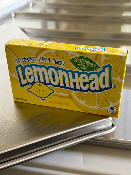 box of candy lemon head sitting on freeze drier trays.