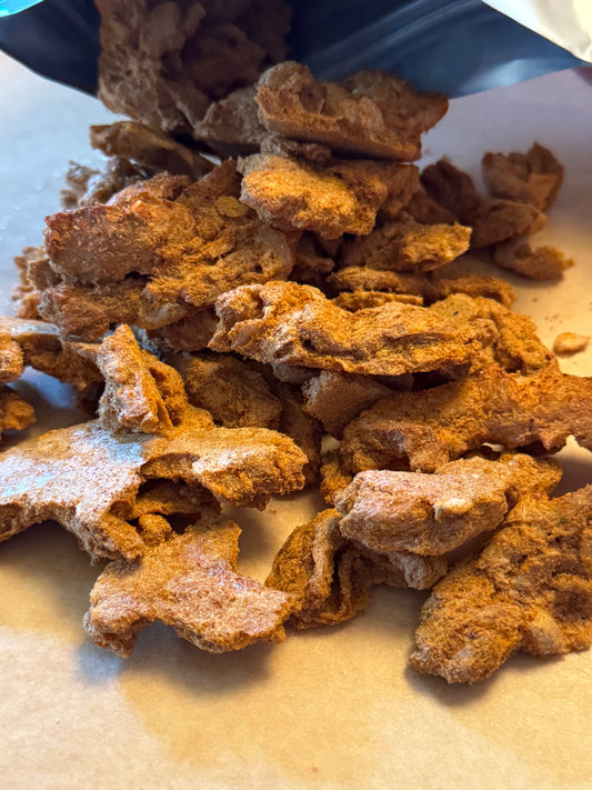 Chunks of appetizing freeze dried protein coming out of a mylar pouch which can be eaten like a jerky snack or rehydrated for a sumptuous, meaty bite.