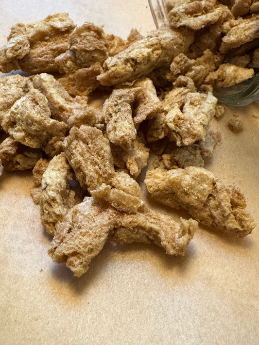 Chunks of appetizing freeze dried protein coming out of a jar lying on its side