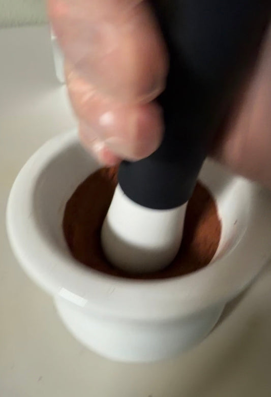Mortar and pestle grinding a Culinary Alchemy flavor base into a fine powder.