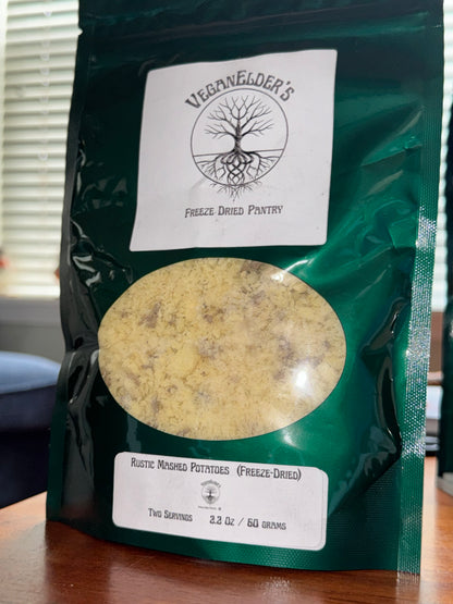 Green package with labels and a round window showing freeze dried mashed potatoes. 