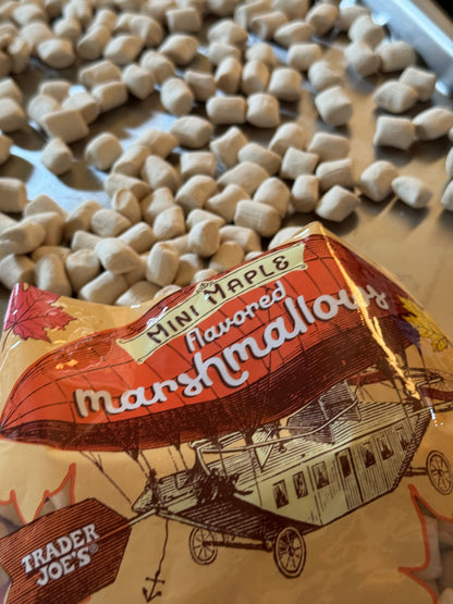 A plastic bag that says mini maple falvored marshmallows from Trader Joe's spilling mini marshmallows on to a tray