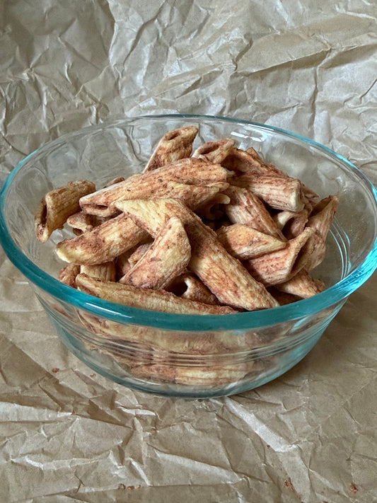 Bowl of freeze-dried Snackaroni Cheezy Marinara pasta pieces.