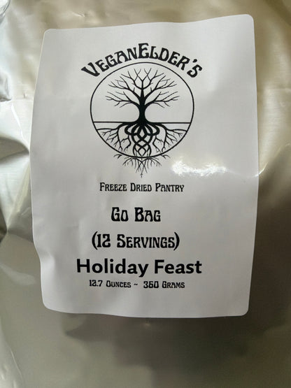 A close-up of a white go bag package of 12 servings of freeze dried Barbecue Protein strips with a black printed label reading 'Vegan Elder's Freeze Dried Pantry' and 'Holiday Feast'.