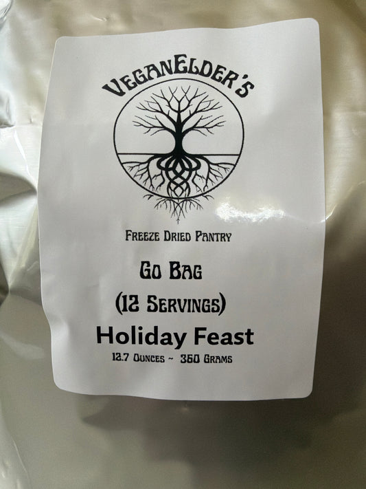 A close-up of a white go bag package of 12 servings of freeze dried Barbecue Protein strips with a black printed label reading 'Vegan Elder's Freeze Dried Pantry' and 'Holiday Feast'.