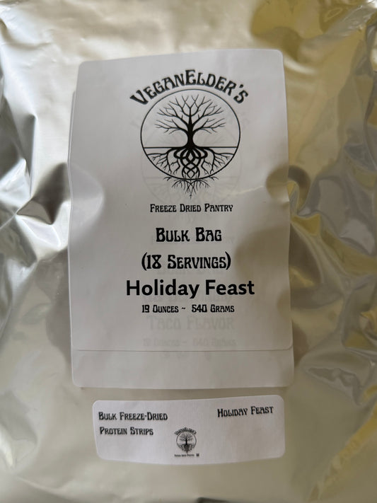 A silver foil pouch of 18 Servings of VeganElder's Bulk Bag Holiday Feast freeze dried pantry protein strips, with a white paper label showing the brand logo and product details.