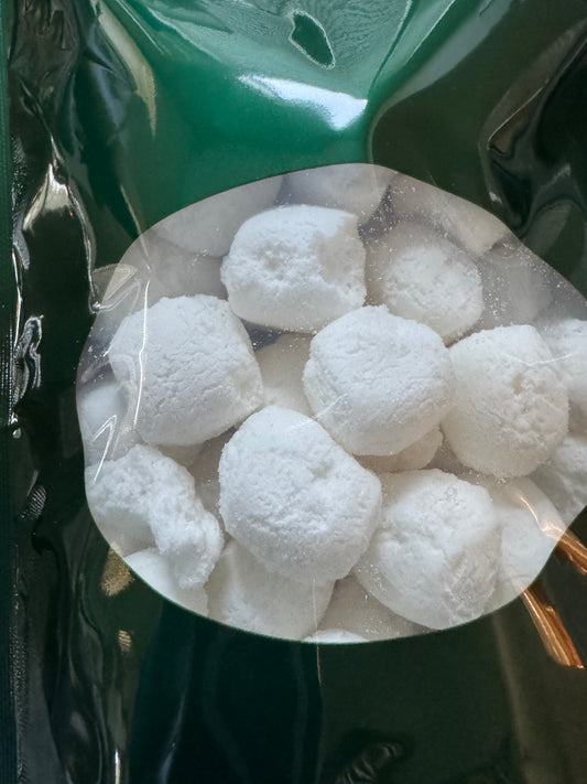 White spherical objects that look like crunchy marshmallows  in a clear plastic bag on a dark background