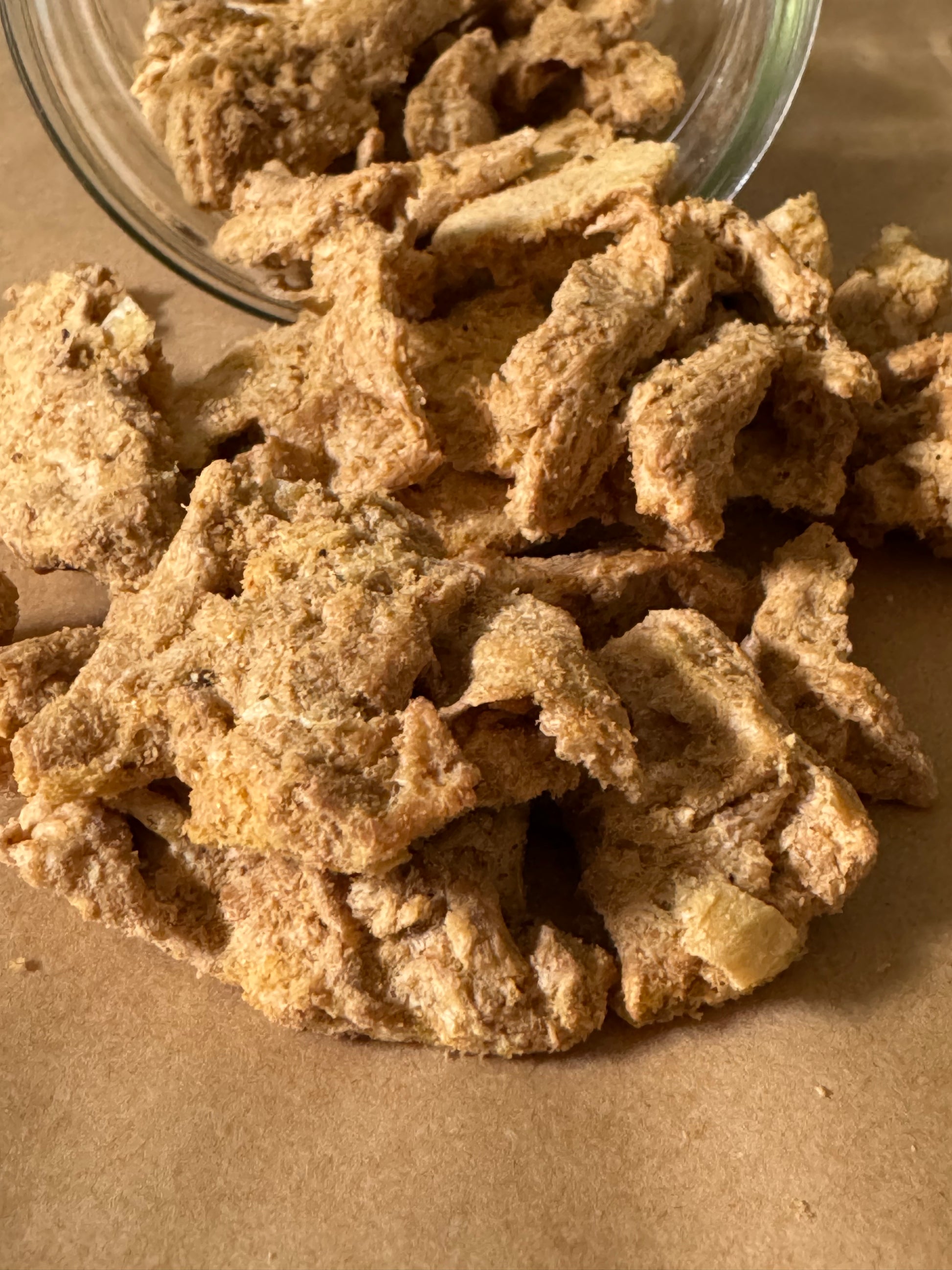 Close up of protein strips that look light and crunchy as they have tumbled out of a jar onto a table