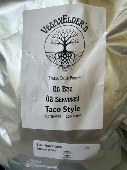 A silver bulk bag of Veganelder's Freeze Dried Pantry 12 servings Go Bag Taco Style Protein strips, featuring a white label with a black tree logo and text, and a smaller label for bulk freeze-dried protein strips.