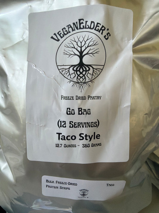 A silver bulk bag of Veganelder's Freeze Dried Pantry 12 servings Go Bag Taco Style Protein strips, featuring a white label with a black tree logo and text, and a smaller label for bulk freeze-dried protein strips.