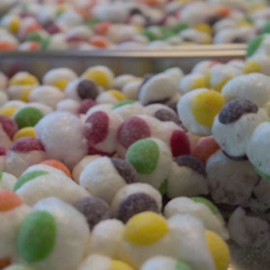 video showing trays of colored candy spheres that look like puffed up Sour Skittles on trays from the freeze drier