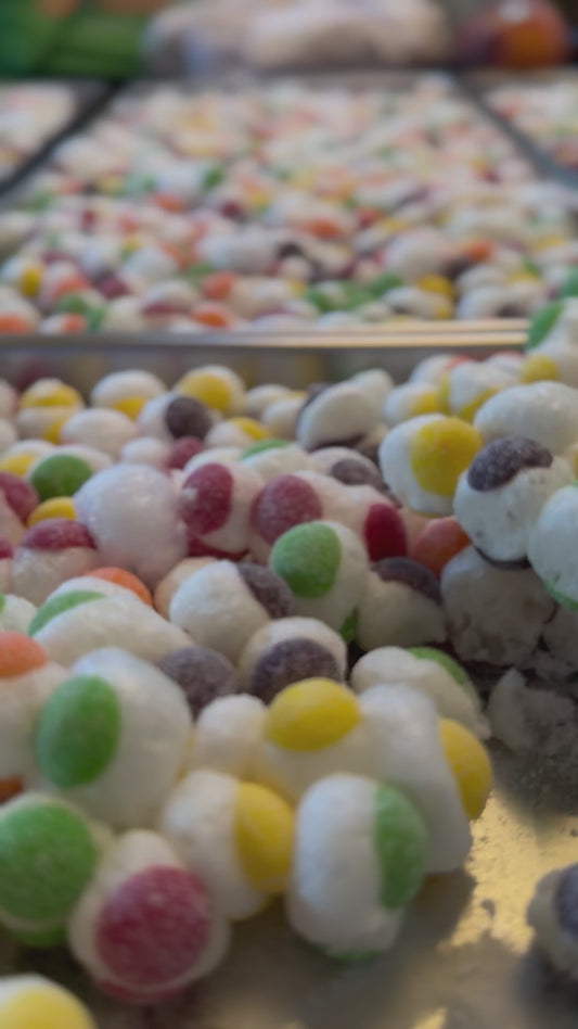 video showing trays of colored candy spheres that look like puffed up Sour Skittles on trays from the freeze drier