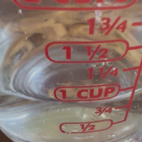 Video showing rehydrating soy curls protein chunks with water from a measuring cup showing 2/3 cups of water pouring over two servings of soy curls