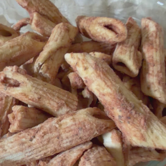 Bowl of freeze-dried Snackaroni Cheezy Marinara pasta pieces captured from different angles