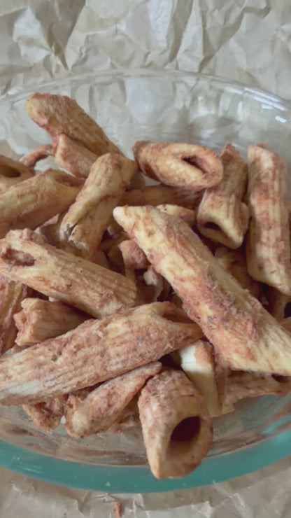 Bowl of freeze-dried Snackaroni Cheezy Marinara pasta pieces captured from different angles