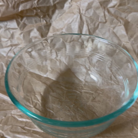 Empty bowl being filled with freeze-dried Snackaroni Cheezy Marinara pasta pieces.