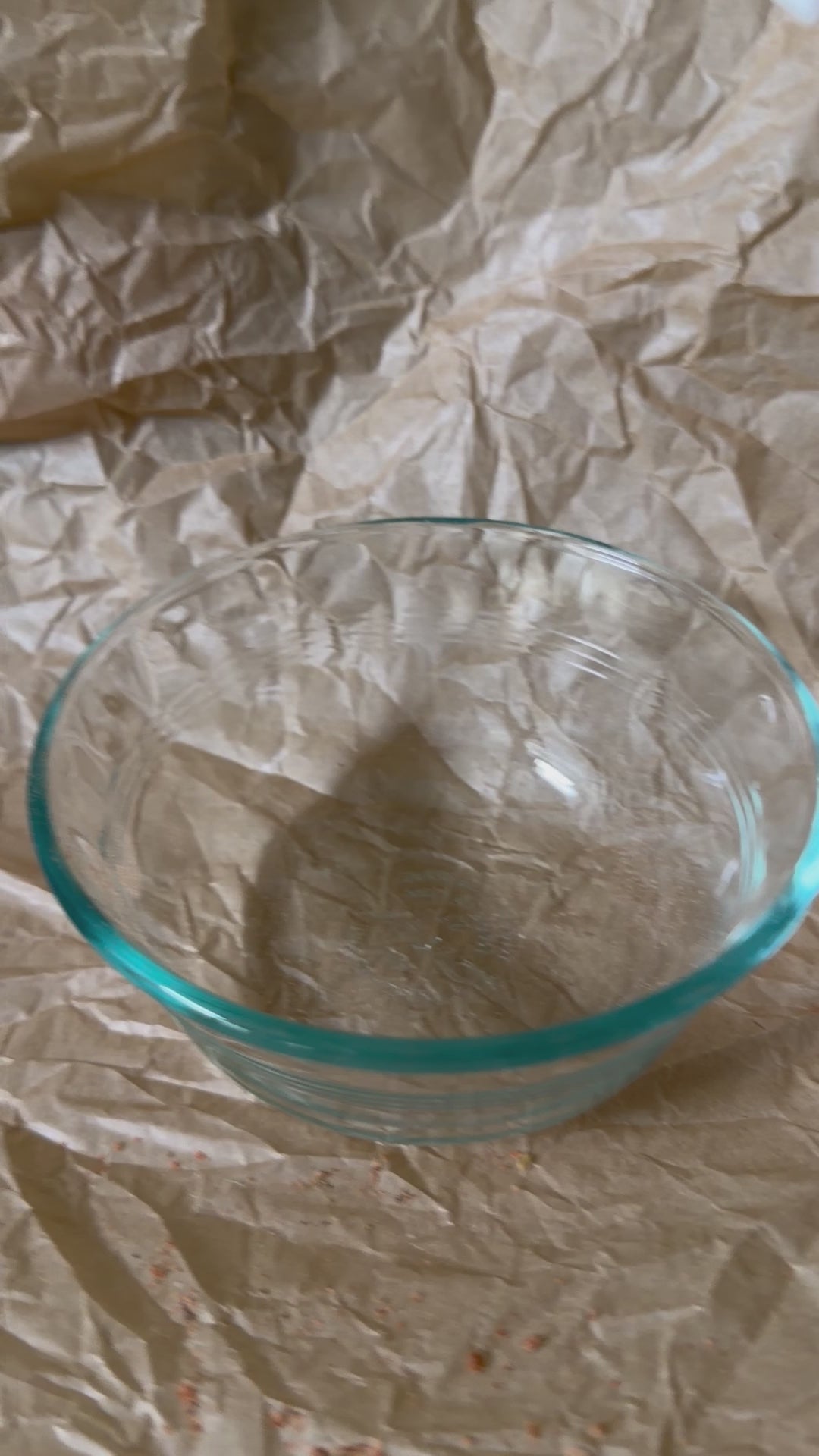 Empty bowl being filled with freeze-dried Snackaroni Cheezy Marinara pasta pieces.